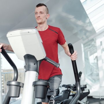 working out on an elliptical trainer in a gym